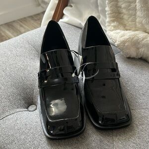 Black patent heeled loafers.